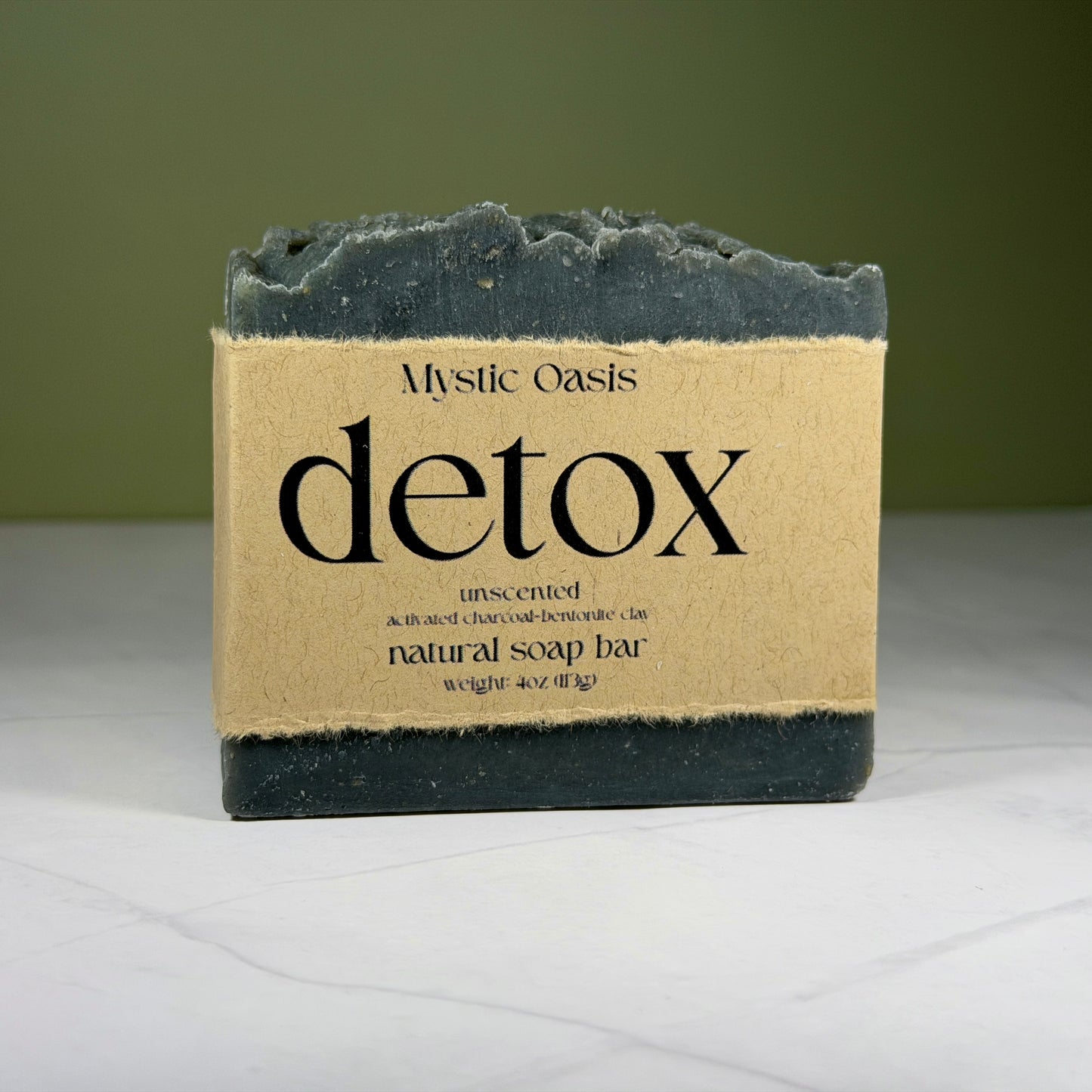 Mystic Oasis detox natural soap bar on a white surface with a green background