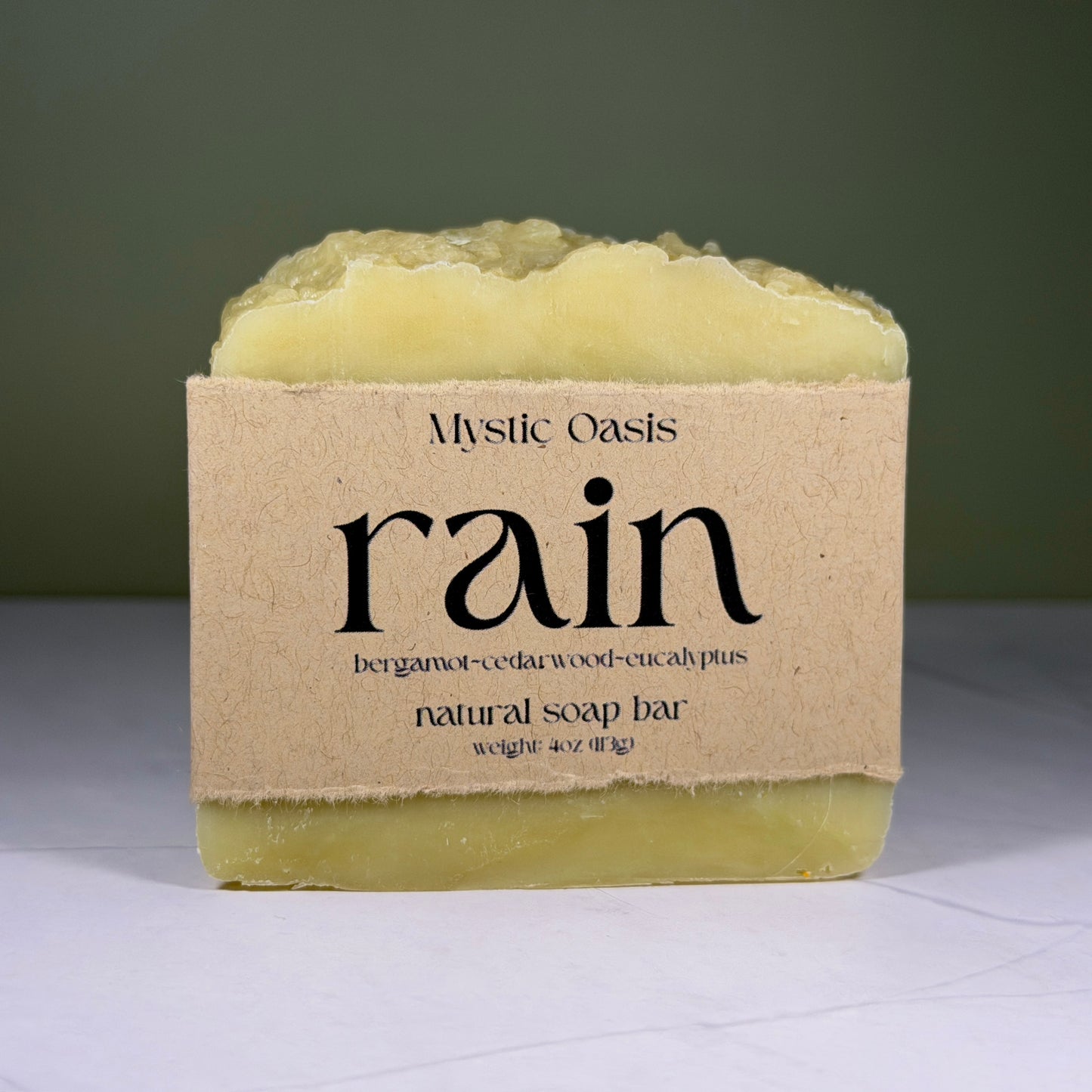 Mystic Oasis rain natural soap bar with a brown label on a white surface.