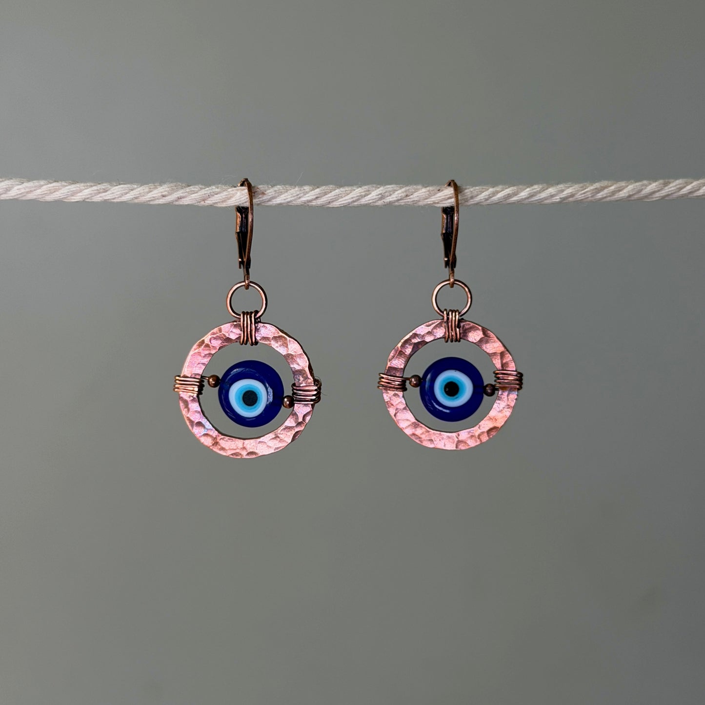 Cooper hoop earrings with glass evil eye bead in the center