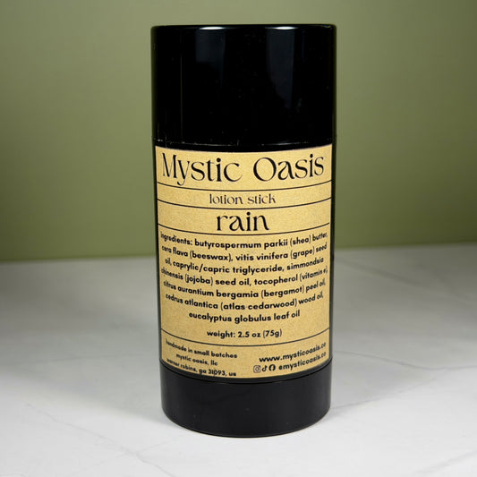 Mystic Oasis lotion stick labeled 'rain' on a white surface with a green background