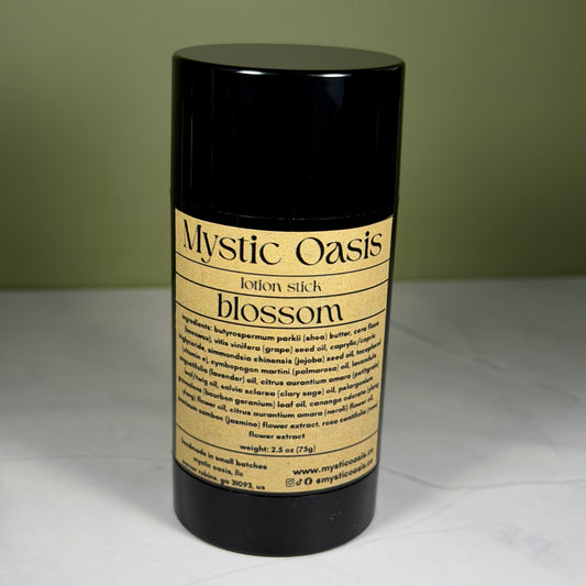 Black lotion stick labeled 'Mystic Oasis' on a white surface with a green background