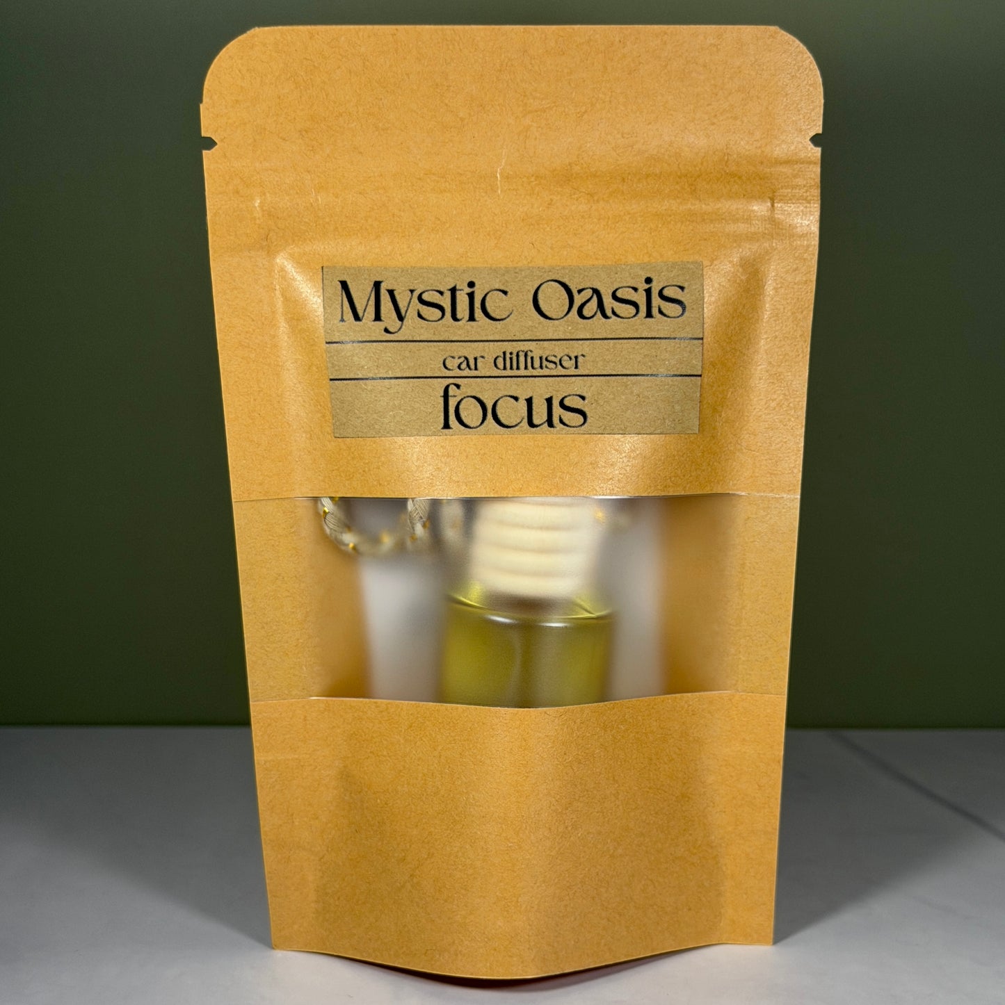 Kraft paper packaging with 'Mystic Oasis' label for a diffuser on a green background