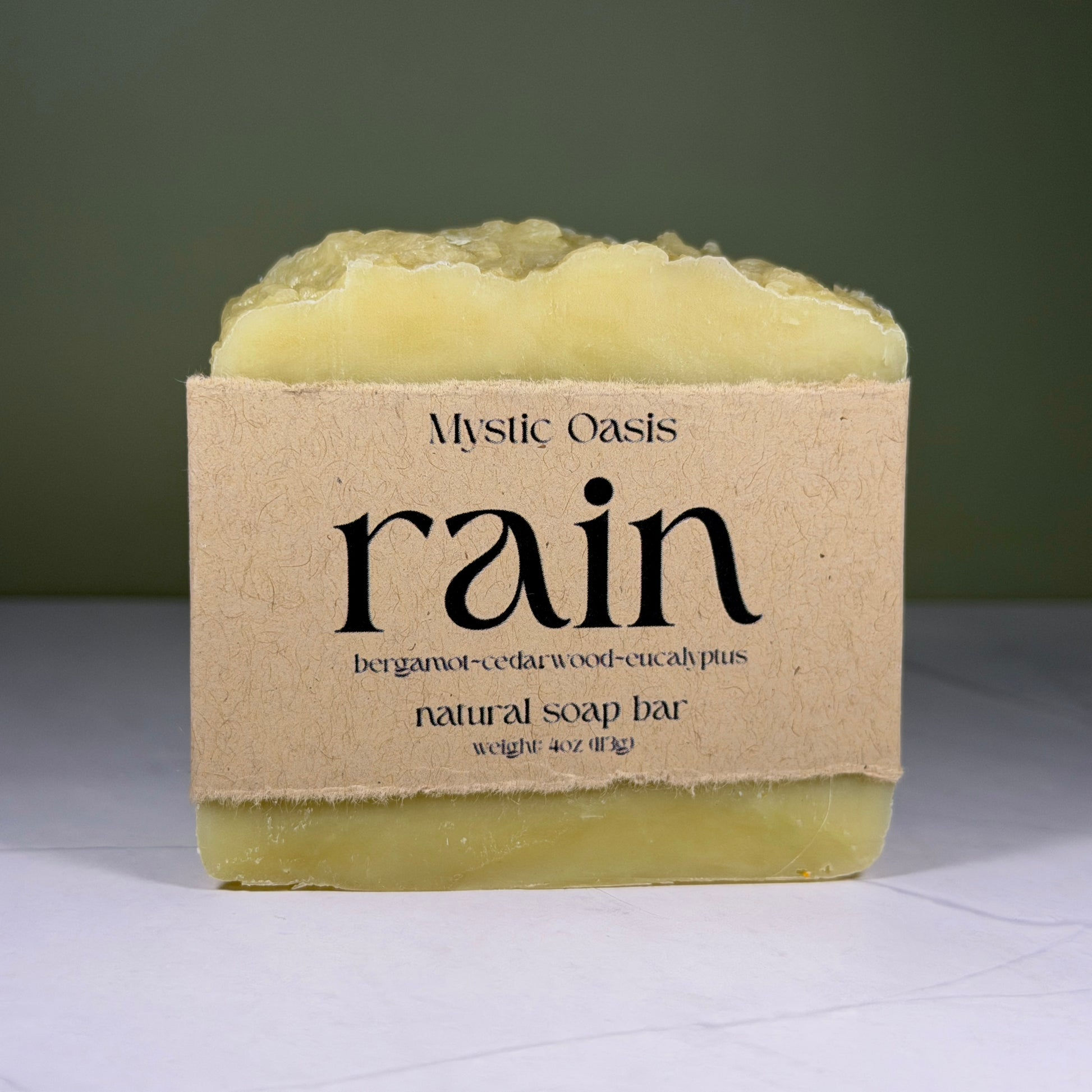 Mystic Oasis rain natural soap bar with a brown label on a white surface.