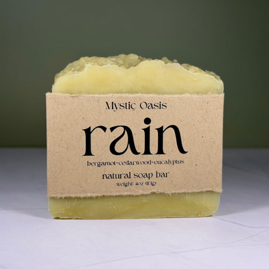 Mystic Oasis rain natural soap bar with a brown label on a white surface.