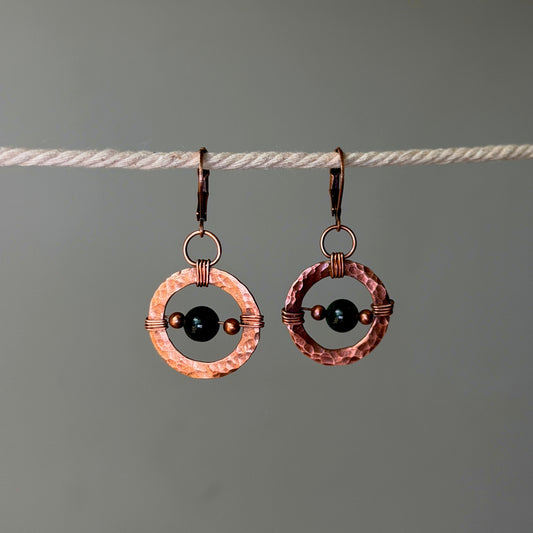 Copper hoop earrings with dark green bead in the center