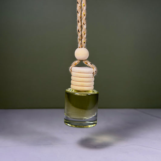 Glass diffuser bottle with wooden beads on a string against a dark background