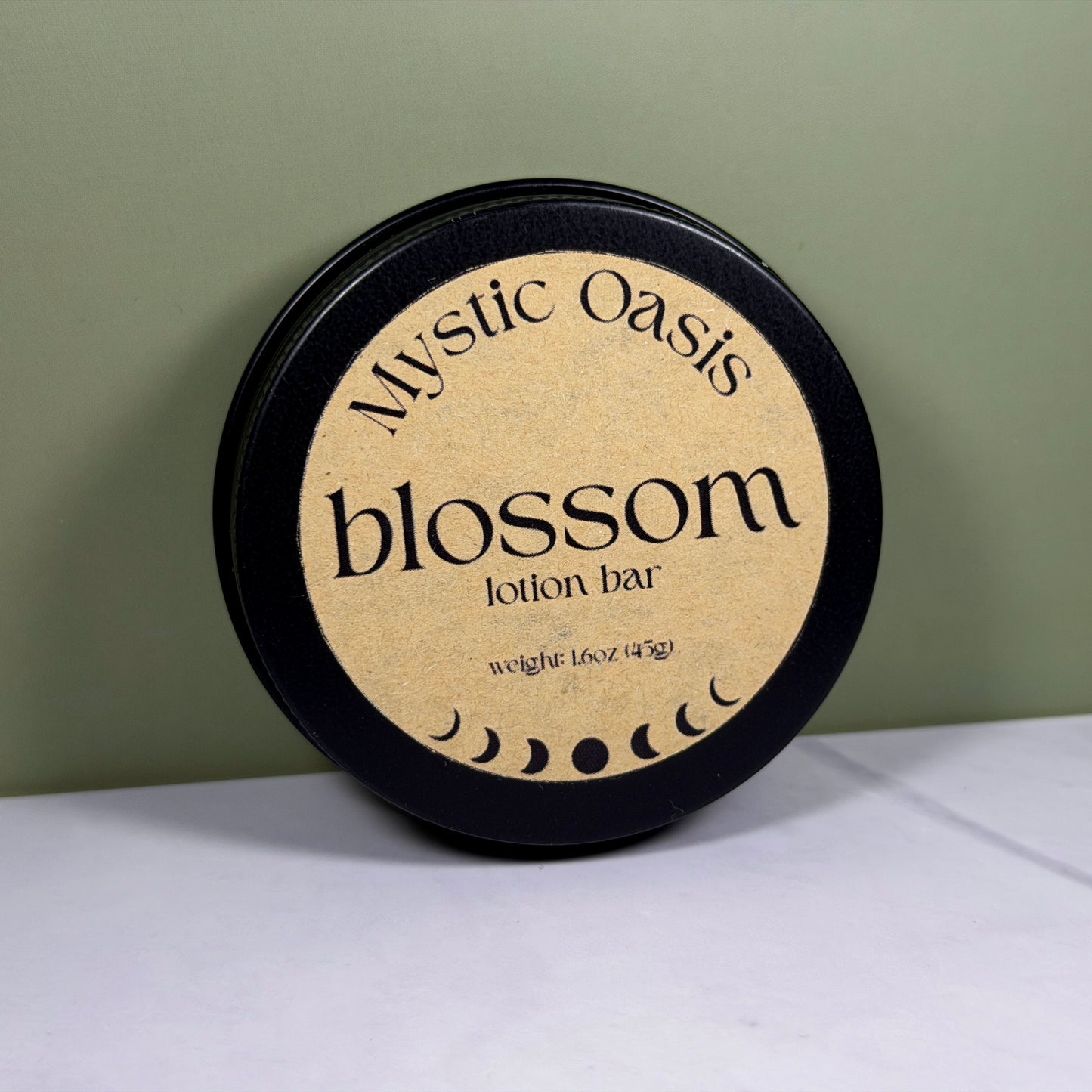 Mystic Oasis blossom lotion bar packaging on a white surface with a green background