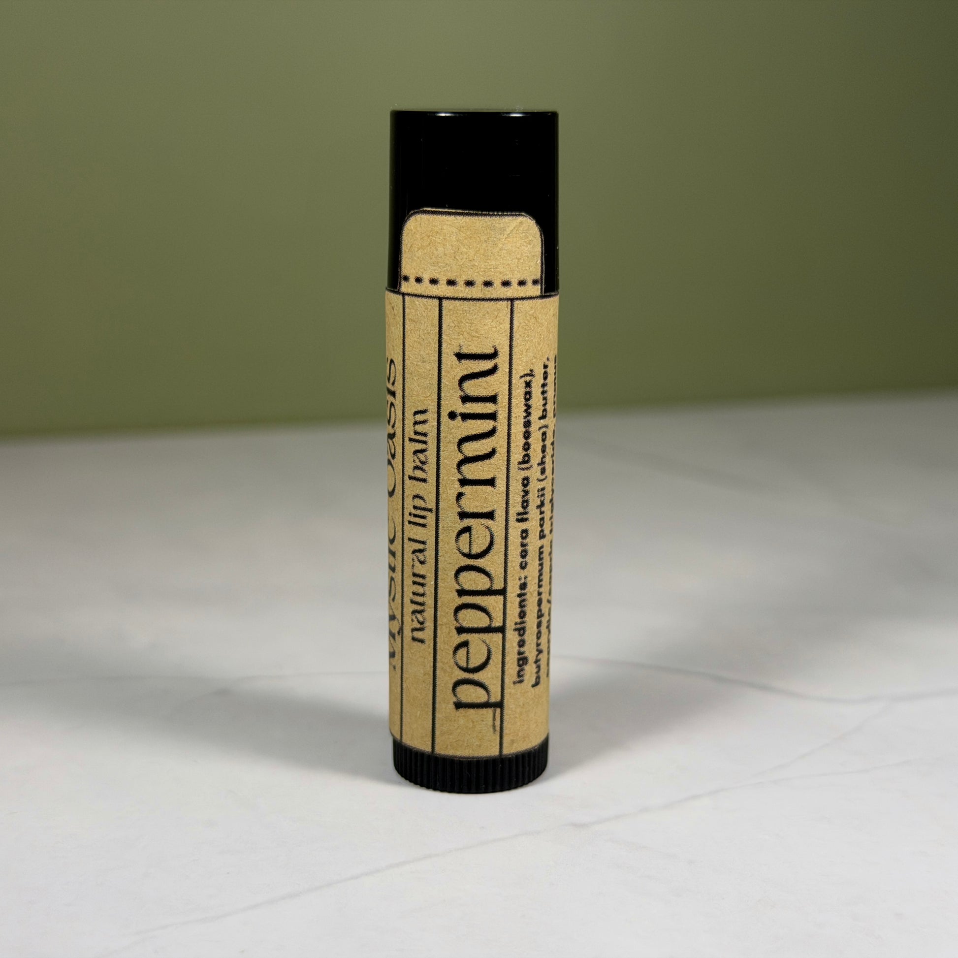 Lip balm with Kraft packaging on a light surface and green background