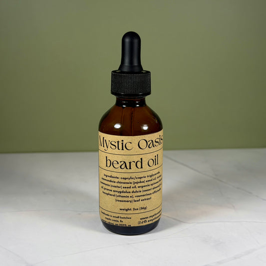 Bottle of Mystic Oasis beard oil with a dropper on a white surface and green background