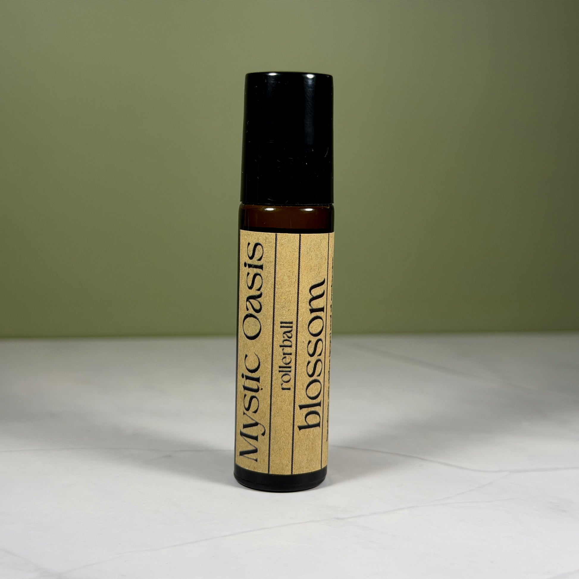 Roll-on bottle labeled 'Mystic Oasis' with 'blossom' on a neutral background