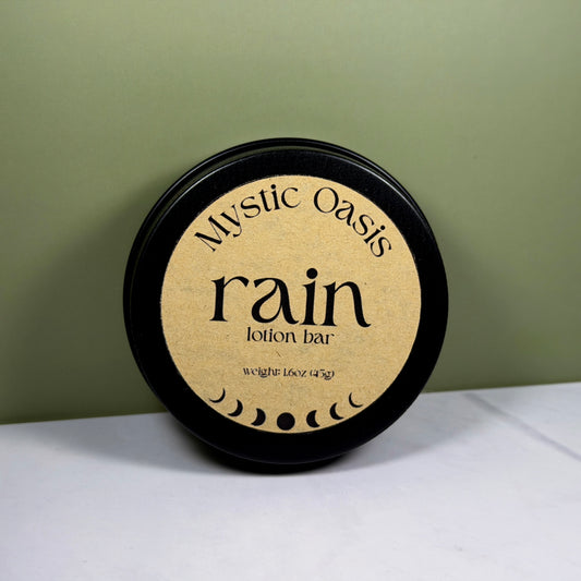 Mystic Oasis rain lotion bar packaging on a white surface with a green background
