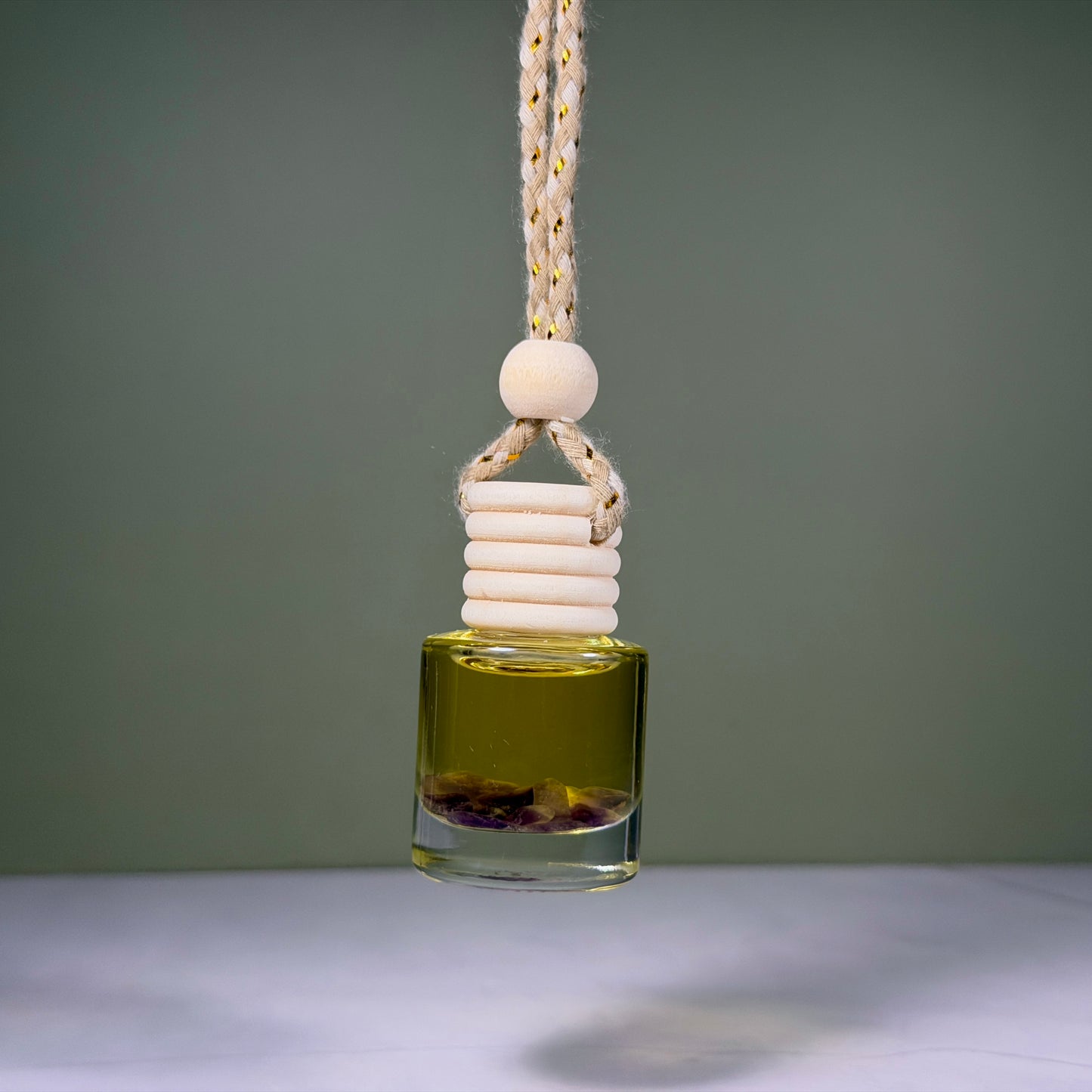 Glass bottle with a rope and wooden bead on a gray background